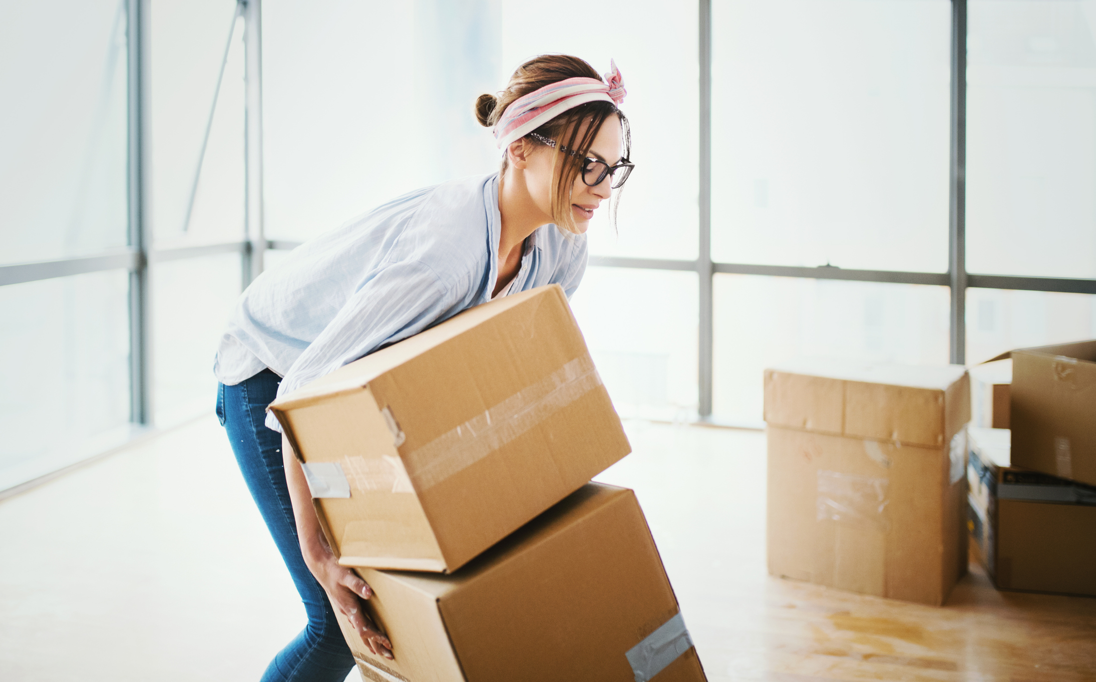 woman moving boxes in a house
