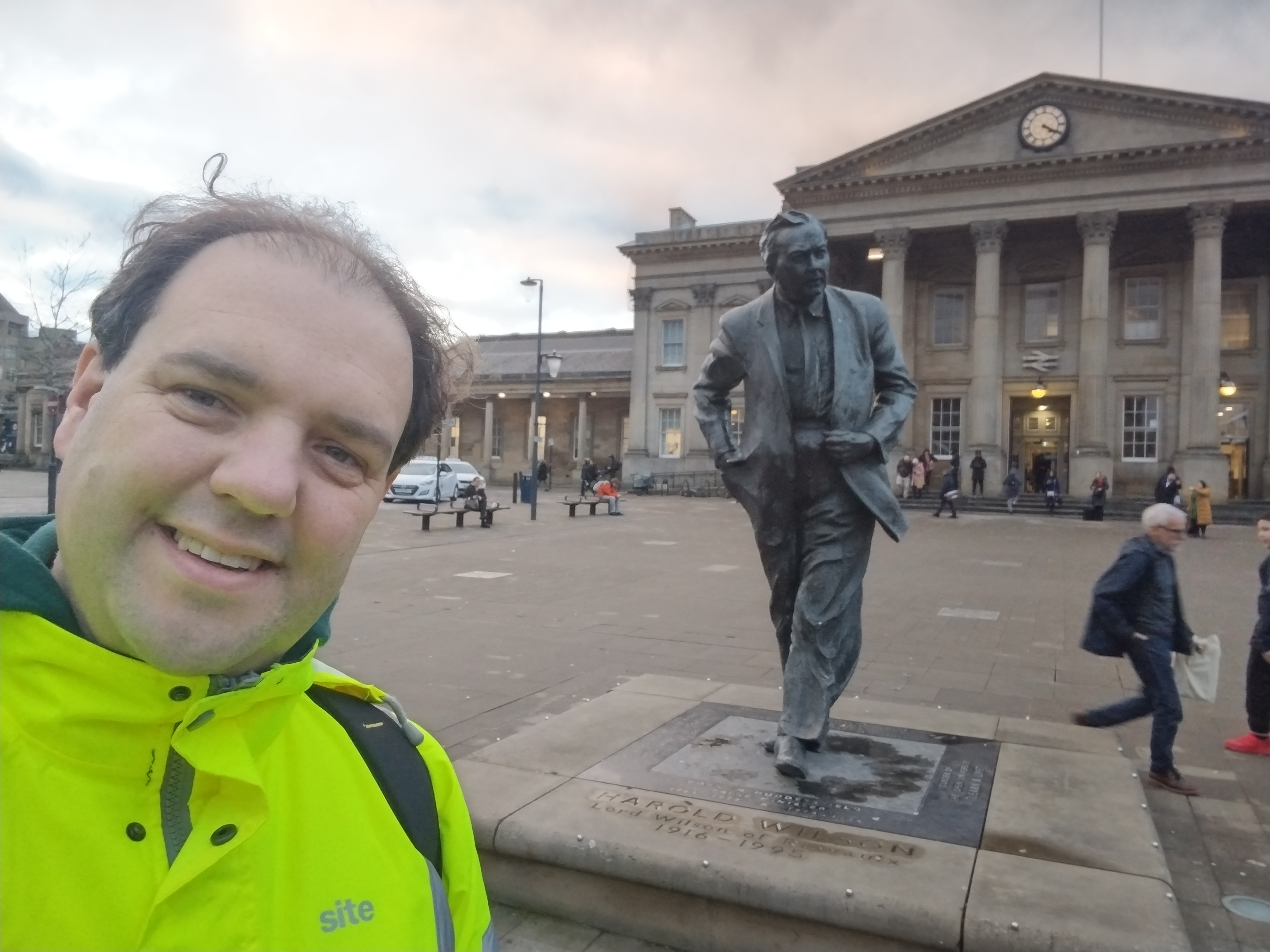 me and a statue of Harold Wilson in front of Huddersfield station