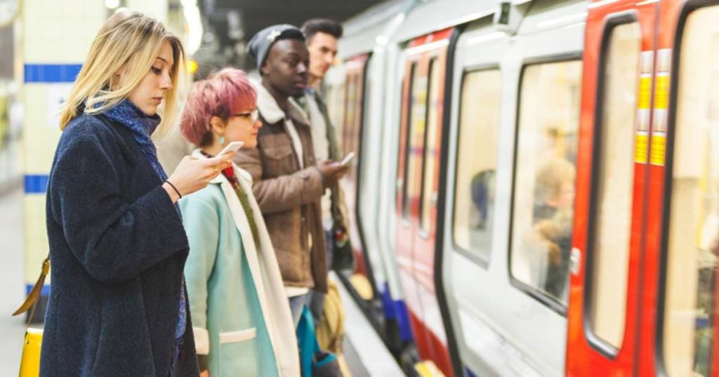 people waiting at a station as an underground train pulls in