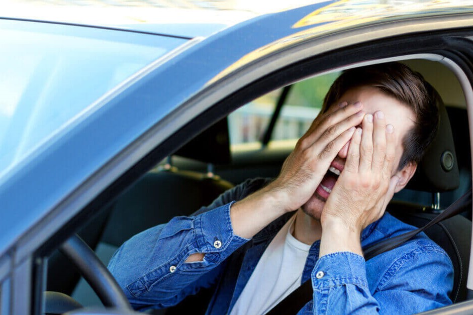 a man sat in a car, experiencing road rage
